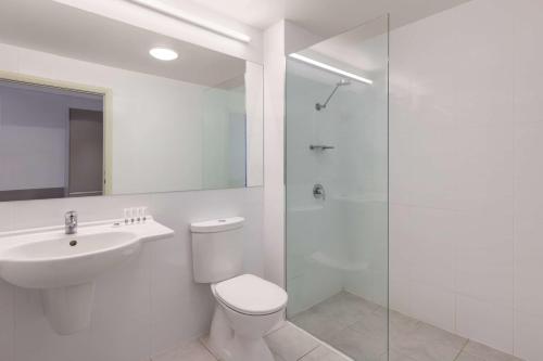 a bathroom with a toilet and a sink and a shower at Travelodge Hotel Hobart Airport in Cambridge