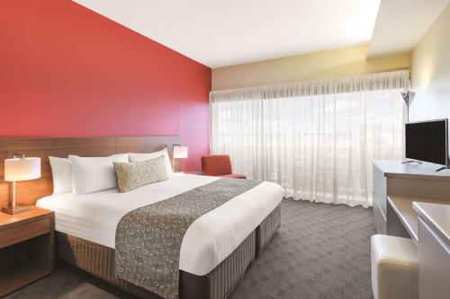 a hotel room with a bed and a television at Travelodge Hotel Hobart Airport in Cambridge