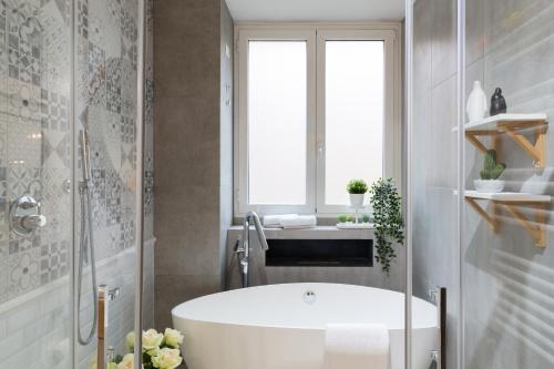 ein Bad mit einer weißen Badewanne und einem Fenster in der Unterkunft GoodVibesHome in Mailand
