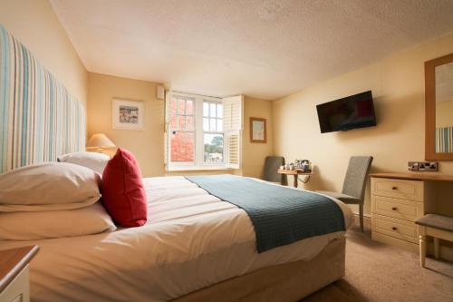 a bedroom with a bed and a desk and a window at The Old Custom House in Padstow