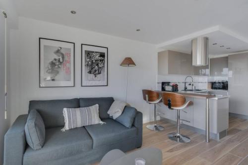 un salon avec un canapé et une cuisine dans l'établissement WE CANNES ! Terrace sea view swimming pool car park Cannes Center, à Cannes