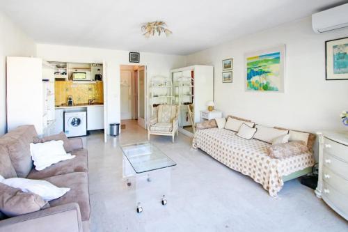 un salon avec un canapé et une table dans l'établissement Cosy Studio Cannes Center beaches shopping and congresses LIVE IN MERLE, à Cannes