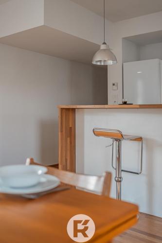 une cuisine avec une table en bois et une plaque de cuisson. dans l'établissement R'Apparts T3 L'Idéal Caserne De Bonne, à Grenoble