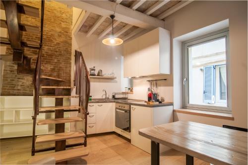 a kitchen with a wooden staircase and a wooden table at La Corte del Grillo in Perugia