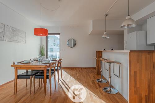 une cuisine et une salle à manger avec une table et des chaises en bois dans l'établissement R'Apparts T3 L'Idéal Caserne De Bonne, à Grenoble