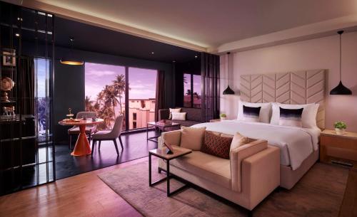 a bedroom with a bed and a living room with a couch at Hyatt Centric Juhu Mumbai in Mumbai