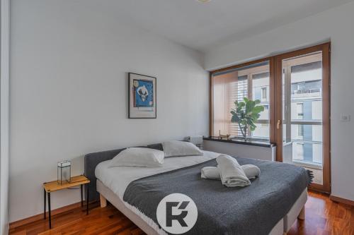 une chambre avec un grand lit et une fenêtre dans l'établissement R'Apparts T3 L'Idéal Caserne De Bonne, à Grenoble