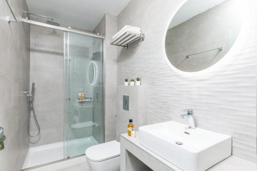 uma casa de banho branca com um lavatório e um chuveiro em Villa Bougainvillea Boutique 1 by Villa Plus em Marathias