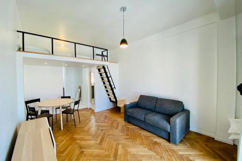 ein Wohnzimmer mit einem Sofa und einem Tisch in der Unterkunft Design apartment ideal for seaside holidays LIVE IN DR FABRE in Juan-les-Pins