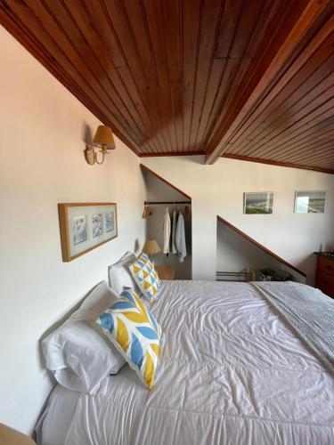 Schlafzimmer mit einem Bett mit Holzdecke in der Unterkunft Foz - Sea View Cottage in Foz do Arelho