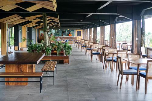 a row of tables and chairs in a restaurant at Teras Hotel Ijen Banyuwangi in Banyuwangi