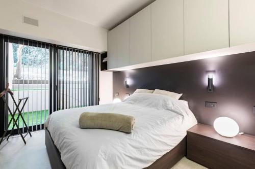 a bedroom with a large bed and a large window at LagoC0C00N - Colazione - 300m stazione - 800m lago in Desenzano del Garda