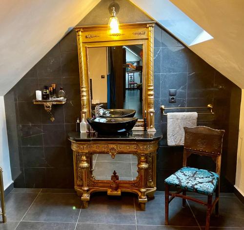 baño con lavabo y espejo grande en Patrimonium Welness Apartments, en Tiszaszentimre