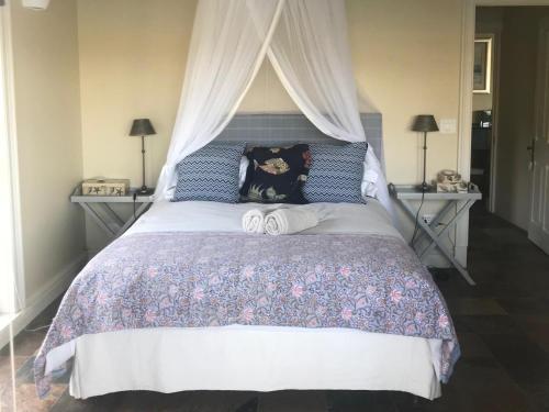 a bedroom with a large bed with a canopy at The Boathouse at Oakhurst Olives in Tulbagh