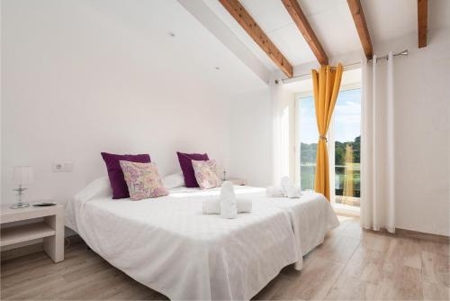 a white bedroom with a large bed and a window at Can Miquel Porro in Llubí