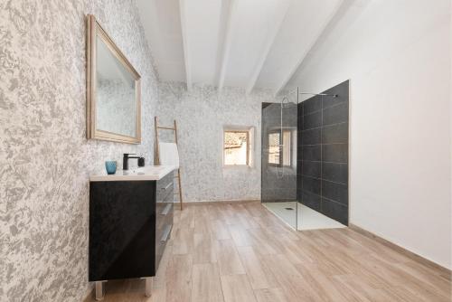 a bathroom with a sink and a shower in a room at Can Miquel Porro in Llubí