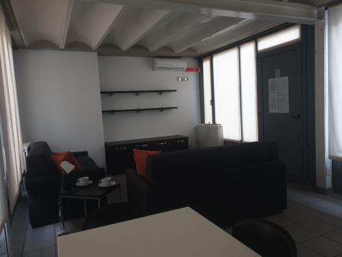 a room with a couch and chairs and a table at Appartamenti tra Lago e Montagna CASA IDEALE LECCO in Lecco