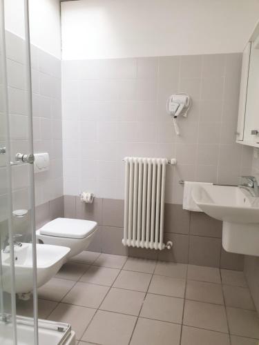 a bathroom with a toilet and a sink and a radiator at Appartamenti tra Lago e Montagna CASA IDEALE LECCO in Lecco
