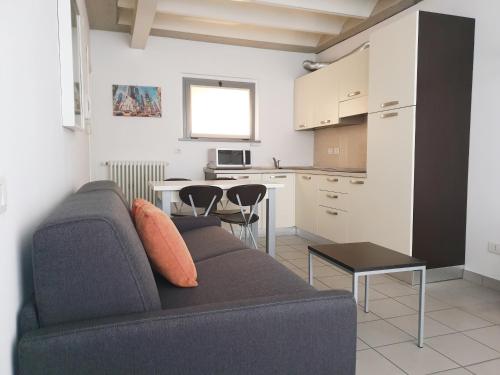 a living room with a couch and a kitchen at Appartamenti tra Lago e Montagna CASA IDEALE LECCO in Lecco