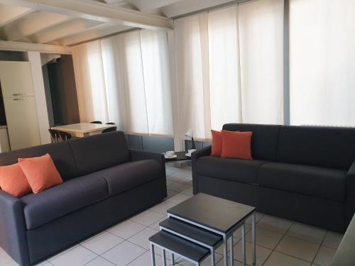 a living room with two couches and a table at Appartamenti tra Lago e Montagna CASA IDEALE LECCO in Lecco