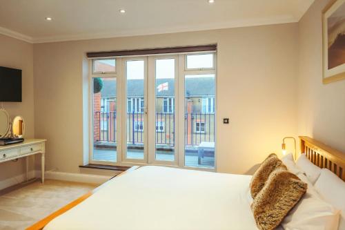 a bedroom with a large bed and a large window at Sovereign Sunrise near to beach in Eastbourne