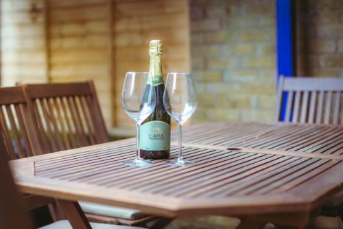 a bottle of wine sitting on a table with two glasses at Sovereign Sunrise near to beach in Eastbourne