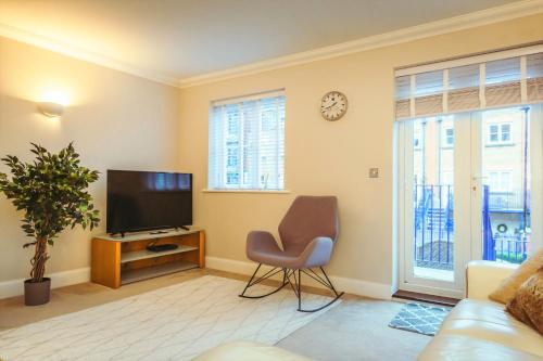 a living room with a television and a chair at Sovereign Sunrise near to beach in Eastbourne