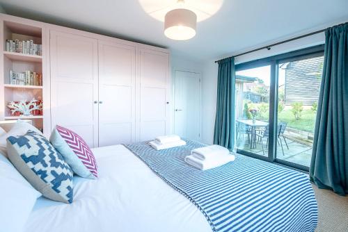 - une chambre dotée d'un lit blanc avec des oreillers bleus et blancs dans l'établissement Little Bramble, Orford, à Orford