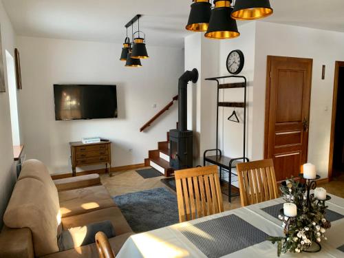 a living room with a table and a fireplace at Domek Siedlisko Poleski Zakątek in Sosnowica
