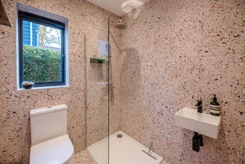 a bathroom with a toilet and a sink and a window at Little Bramble, Orford in Orford