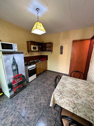 a kitchen with a refrigerator and a table and a microwave at La Posada De Gogg Apartamentos in Bella Vista