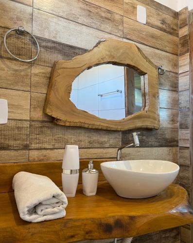 a bathroom with a sink and a mirror at Chalé Lampião BG in Barra Grande