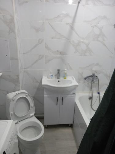 a white bathroom with a toilet and a sink at Астана 3 in Oral