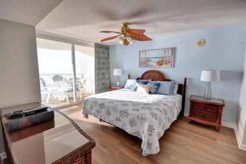 sypialnia z łóżkiem i wentylatorem sufitowym w obiekcie Crescent Shores 911 Condo w mieście North Myrtle Beach
