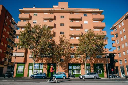 a person walking two dogs in front of a building at Grandera Apart`s - Lliri 32 in Valencia