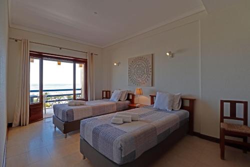 twee bedden in een kamer met uitzicht op de oceaan bij Monte Gordo Beachview 2 by Homing in Monte Gordo
