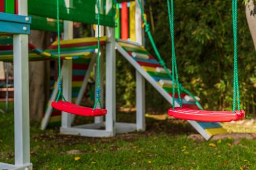 a playground with two swings and a slide at Villa das Quebradas by An Island Apart in Funchal