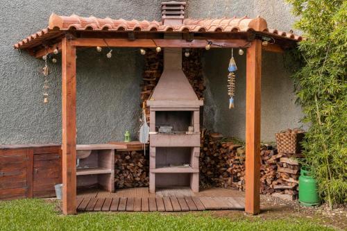 a wooden pergola with a table and a grill at Villa das Quebradas by An Island Apart in Funchal