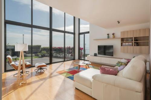a living room with a white couch and large windows at Villa das Quebradas by An Island Apart in Funchal