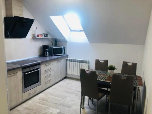 a kitchen with a table with a microwave and a kitchen with a tableablish at Vila Nona Apartment in Sibiu