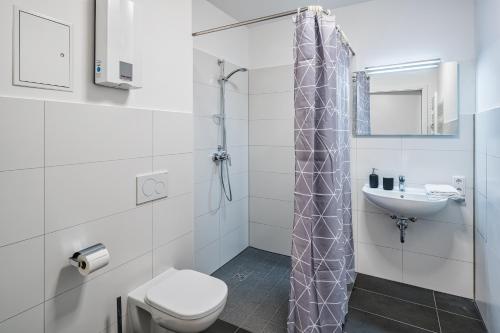 a bathroom with a shower and a toilet and a sink at NorthApartments Dresden am Park in Dresden