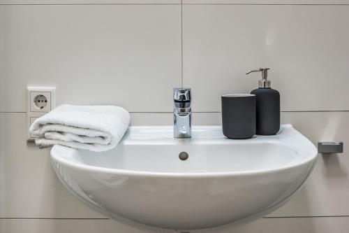 a white sink in a bathroom with towels on it at NorthApartments Dresden am Park in Dresden