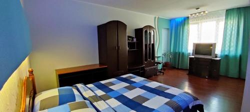 - une chambre avec un lit, une commode et une télévision dans l'établissement Apartment Haharina 62, à Kharkov