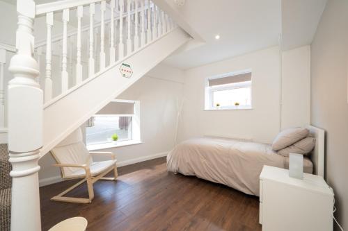 1 dormitorio blanco con 1 cama y escalera en Old Exchange Court, en Belfast