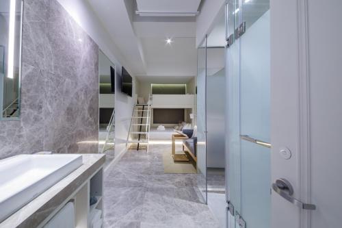 a bathroom with a sink and a mirror at Charterhouse Causeway Bay in Hong Kong