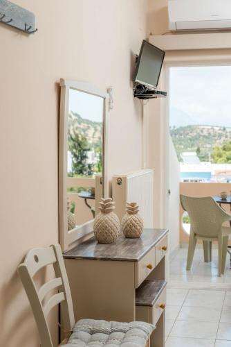 a room with a mirror and a table with chairs at Filia Apartments in Pitsidia