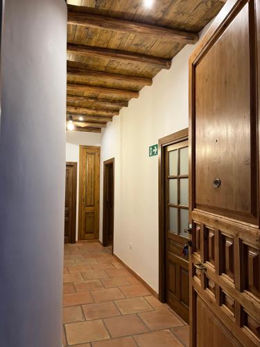 a hallway with a wooden ceiling and a door at El Carmen in Benalúa de Guadix