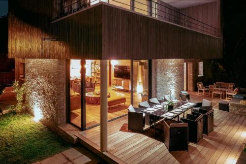 une terrasse avec une table et des chaises ainsi qu'une maison dans l'établissement Villa Renajolo 16 pers piscine chauffée 2 min plage en voiture, à Sainte-Lucie de Porto-Vecchio