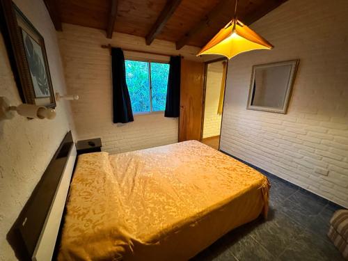 ein Schlafzimmer mit einem gelben Bett in einem Zimmer mit einem Fenster in der Unterkunft La Posada De Gogg Apartamentos in Bella Vista
