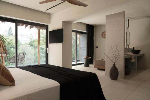 The Syntopia Hotel - Adults Only في أذيليانوس كامبوس: غرفة نوم بسرير ومروحة سقف